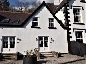 une maison blanche avec un toit noir dans l'établissement 3 Bed in Conwy TYGOS, à Llangelynin