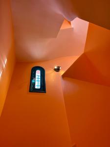 eine Fernbedienung in einem Zimmer mit orangefarbener Decke in der Unterkunft Spacious 3-Floor Riad in Marrakesch
