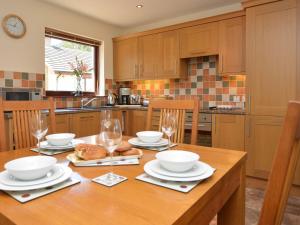 a kitchen with a wooden table with plates and glasses at 2 Bed in Bamburgh 36338 in East Ord