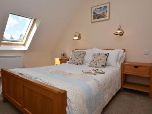 a bedroom with a bed with a book on it at 2 Bed in Bamburgh 36338 in East Ord