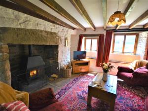 a living room with a stone fireplace and a couch at 3 Bed in Widecombe-in-the-Moor 36683 in Widecombe in the Moor