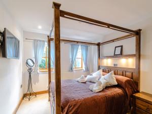 a bedroom with a wooden canopy bed in a room at 3 Bed in York 37254 in Fangfoss