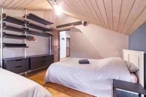 a bedroom with two beds and a wooden ceiling at La Polaire - 3 chambres télécabine à 200m in Ax-les-Thermes