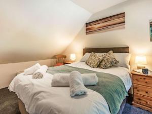 2 Bed in North Tawton 40336 في نورث تاوتن: غرفة نوم بسريرين وخزانة فيها مصباحين