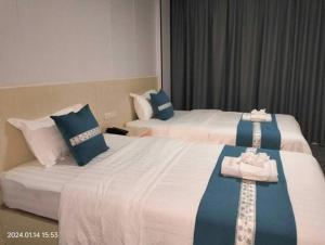 two beds in a hotel room with blue and white at Venice Star Grand Hotel in Manila