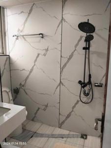 a shower in a bathroom with a marble wall at Venice Star Grand Hotel in Manila