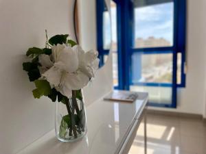 eine Vase voller weißer Blumen auf einem Tisch in der Unterkunft Apto con vistas a la playa de La Patacona in Valencia