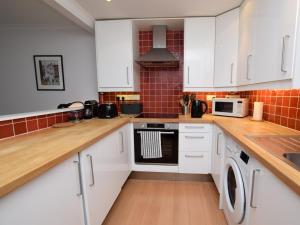 uma cozinha com armários brancos e um forno com placa de fogão em 3 Bed in City Centre E1986 em Edimburgo