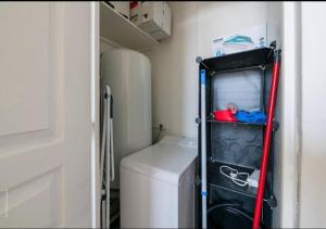 a small laundry room with a refrigerator and a washer at New York in Montargis