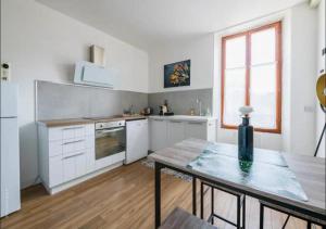 a kitchen with white cabinets and a table and a window at New York in Montargis