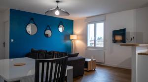 un salon avec une table et un mur bleu dans l'établissement La petite Roche - Spacieux T2 à Poitiers, à Poitiers