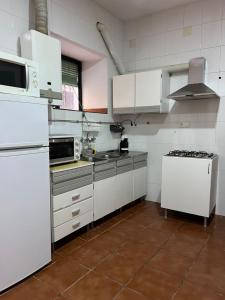 a kitchen with white cabinets and a stove top oven at Casa Tita Maria in Trevélez