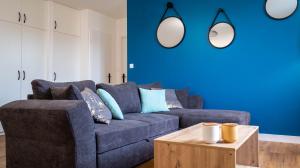 a blue living room with a couch and a table at La petite Roche - Spacieux T2 à Poitiers in Poitiers