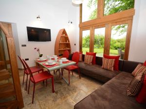 a living room with a couch and a table and chairs at 2 Bed in Widemouth Bay 31962 in Bridgerule