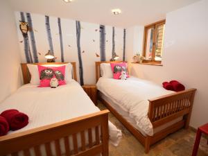 two beds in a room with trees on the wall at 2 Bed in Widemouth Bay 31962 in Bridgerule
