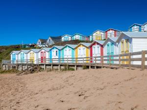 a row of colorful houses on a beach at 2 Bed in Widemouth Bay 31962 in Bridgerule