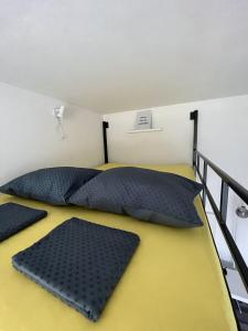 una camera con 2 letti con cuscini neri di Hiška na hribu ad Ancarano