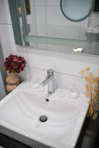 a bathroom sink with a faucet and a mirror at Gandersheimer Boardinghouse in Bad Gandersheim