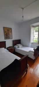 a bedroom with two beds and a window at Gestiona2R - Narganes Mar y Montaña, ideal familias in Narganes