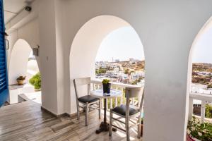 a dining room with arched windows and a table and chairs at Palm in Ios Chora