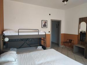 a bedroom with two bunk beds and a chair at Hotel Al Faro in Licata