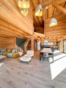 sala de estar con techos de madera, mesa y sillas en Chalet ECRIN DES VIGNES en Les Vigneaux