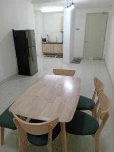 a table and chairs in a room with a refrigerator at BSP21 Homestay in Jenjarum
