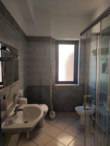 a bathroom with a sink and a toilet and a shower at Hotel Al Faro in Licata