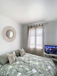 1 dormitorio con 1 cama y TV de pantalla plana en Appartement proche Disneyland, en Bailly-Romainvilliers