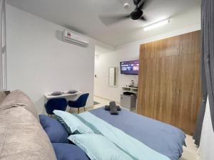 a bedroom with a blue bed and a tv at Myna Suite & Lenore at Alanis Residence Sepang, KLIA Homestay Apartment in Sepang