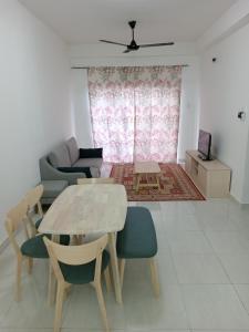a living room with a table and chairs and a couch at BSP21 Homestay in Jenjarum