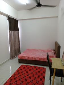 a bedroom with a bed and a table and a red rug at BSP21 Homestay in Jenjarum