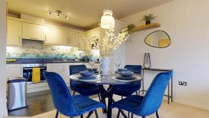a dining room with a table and blue chairs at Stylish Central Apartment in Beckenham