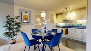comedor con mesa y sillas azules en Stylish Central Apartment, en Beckenham