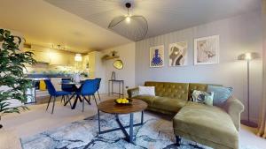 Stylish Central Apartment في بيكنهام: غرفة معيشة مع أريكة وطاولة