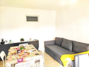 ein Wohnzimmer mit einem Sofa und einem Tisch in der Unterkunft Le Bradford YourHostHelper in Cannes