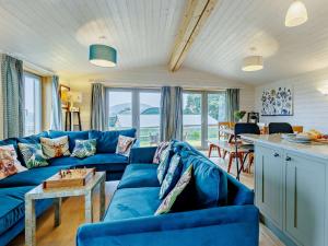 ein Wohnzimmer mit einem blauen Sofa und einem Tisch in der Unterkunft 4 Bed in Sheinton 93398 in Leighton