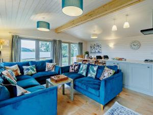 ein Wohnzimmer mit blauen Sofas und eine Küche in der Unterkunft 4 Bed in Sheinton 93398 in Leighton