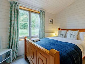 ein Schlafzimmer mit einem Bett und einem großen Fenster in der Unterkunft 4 Bed in Sheinton 93398 in Leighton