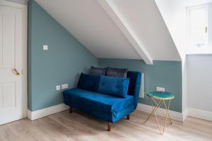 a blue couch in a room with a blue wall at CoHost - Sky high in Bristol in Bristol