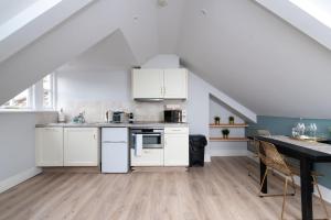 a kitchen with white cabinets and a dining table at CoHost - Sky high in Bristol in Bristol