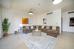 a living room with a couch and a table at LUXFolio Retreats - Spacious 3 Bed - Marina Living in Dubai