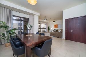 a dining room with a wooden table and chairs at LUXFolio Retreats - Spacious 3 Bed - Marina Living in Dubai
