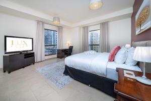 a bedroom with a large bed and a flat screen tv at LUXFolio Retreats - Spacious 3 Bed - Marina Living in Dubai