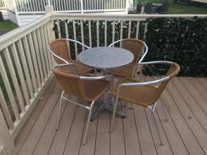 a table and two chairs on a deck at Hot Tub Accommodation Static North Wales in Kinmel Bay