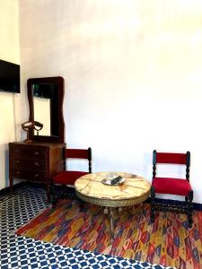 a room with a table and two chairs and a mirror at Riad Dar Chrifa in Fez