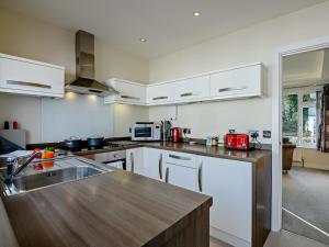 cocina con armarios blancos y encimera de madera en 2 Bed in Mudeford 93458 en Christchurch