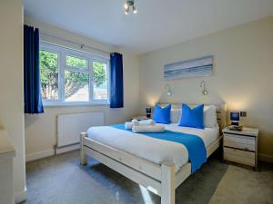 a bedroom with a large bed with blue pillows at 2 Bed in Mudeford 93458 in Christchurch