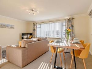 a living room with a couch and a table at 3 Bed in Mudeford 93459 in Christchurch