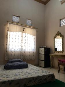 1 dormitorio con cama, ventana y vestidor en Griya Erlangga, en Kediri